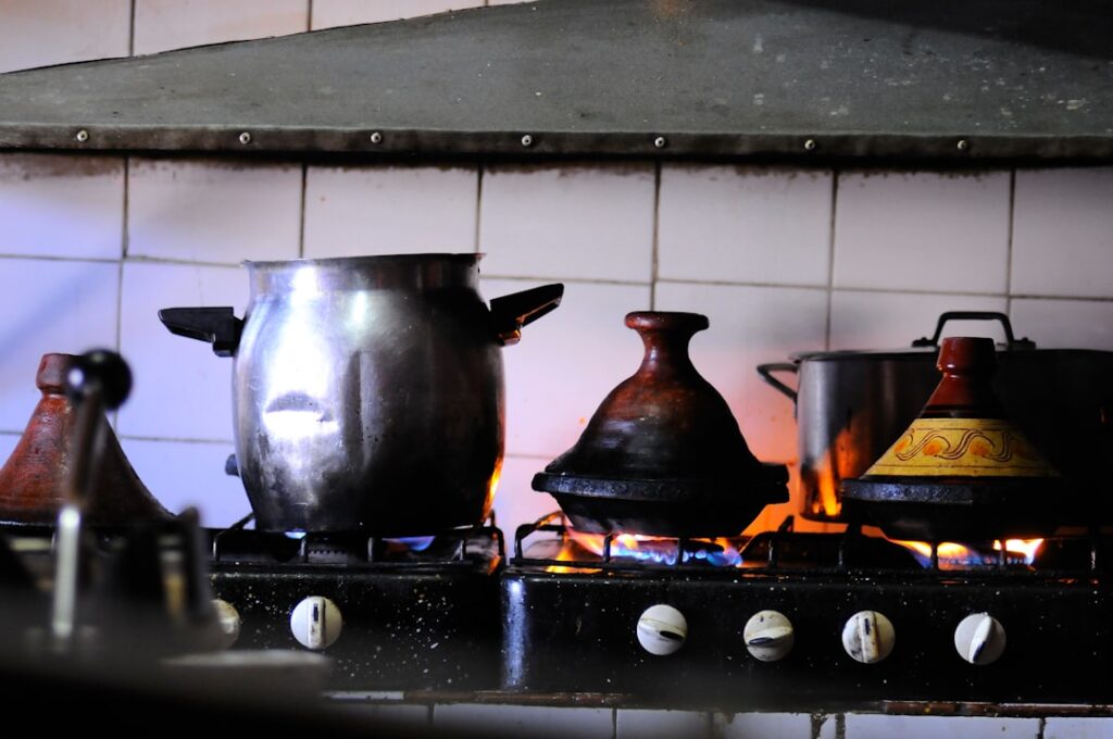Close-up shot of a large cast iron Dutch oven on an RV stovetop with a complete one-pot meal cooking inside - showing layers