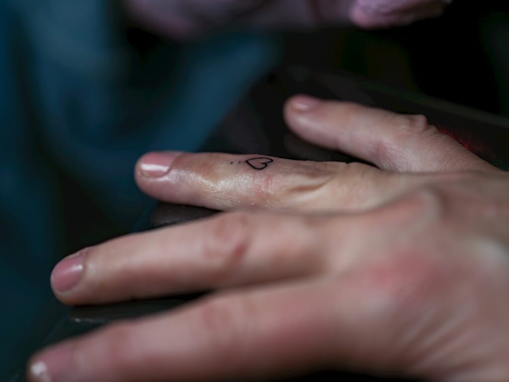 Close-up of hands using a digital multimeter to test electrical connections on an RV slide-out motor assembly, with the motor